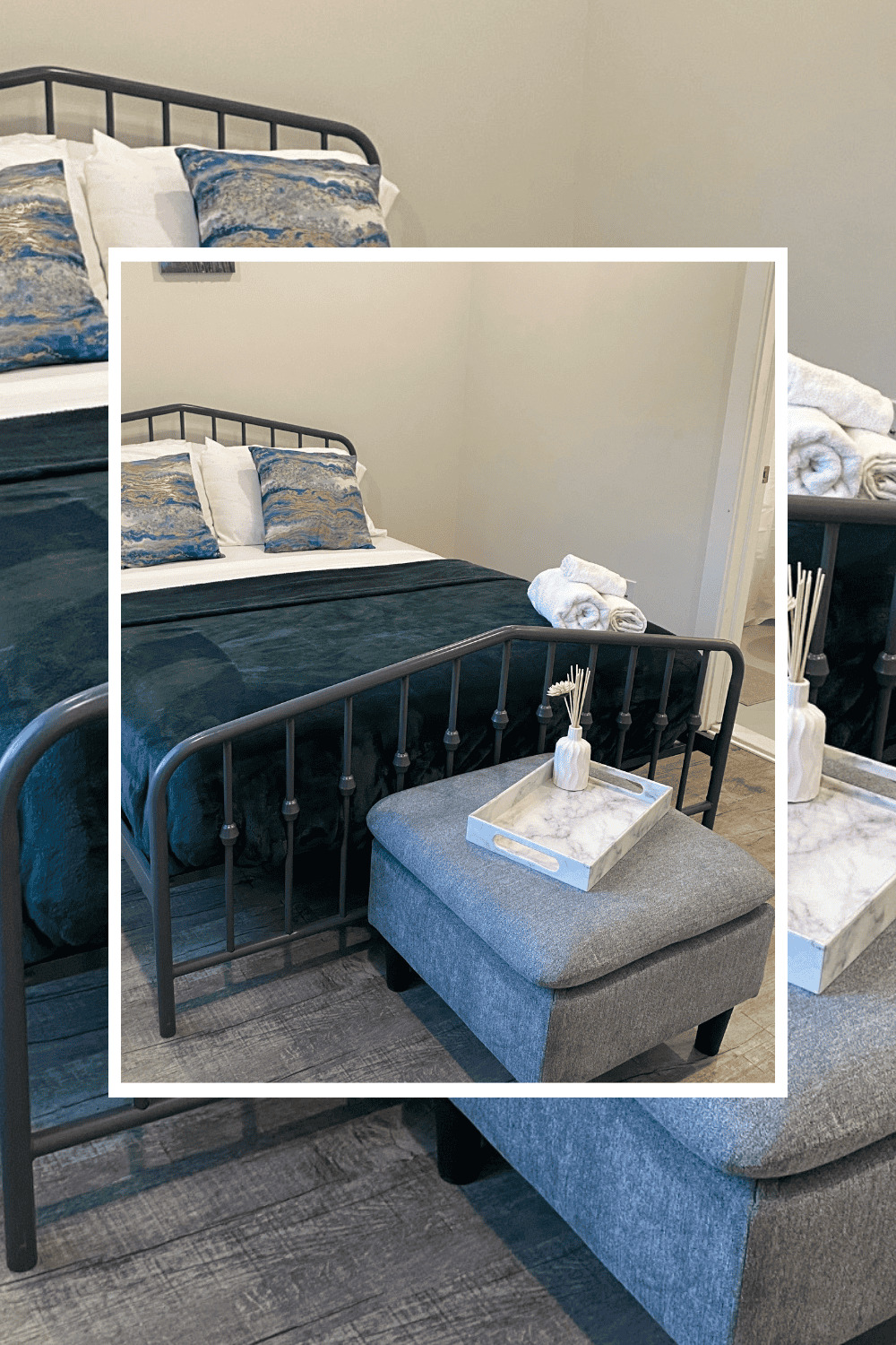 Modern bedroom featuring a black metal bed frame, plush pillows, and a cozy ottoman with decorative.